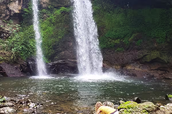 Hidden waterfall surrounded by lush greenery in Bangata